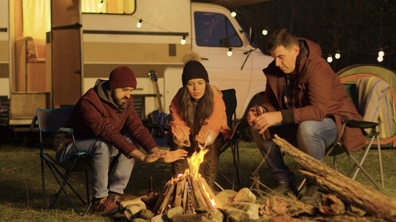 Friends sitting around campfire during a Kodaikanal group stay
